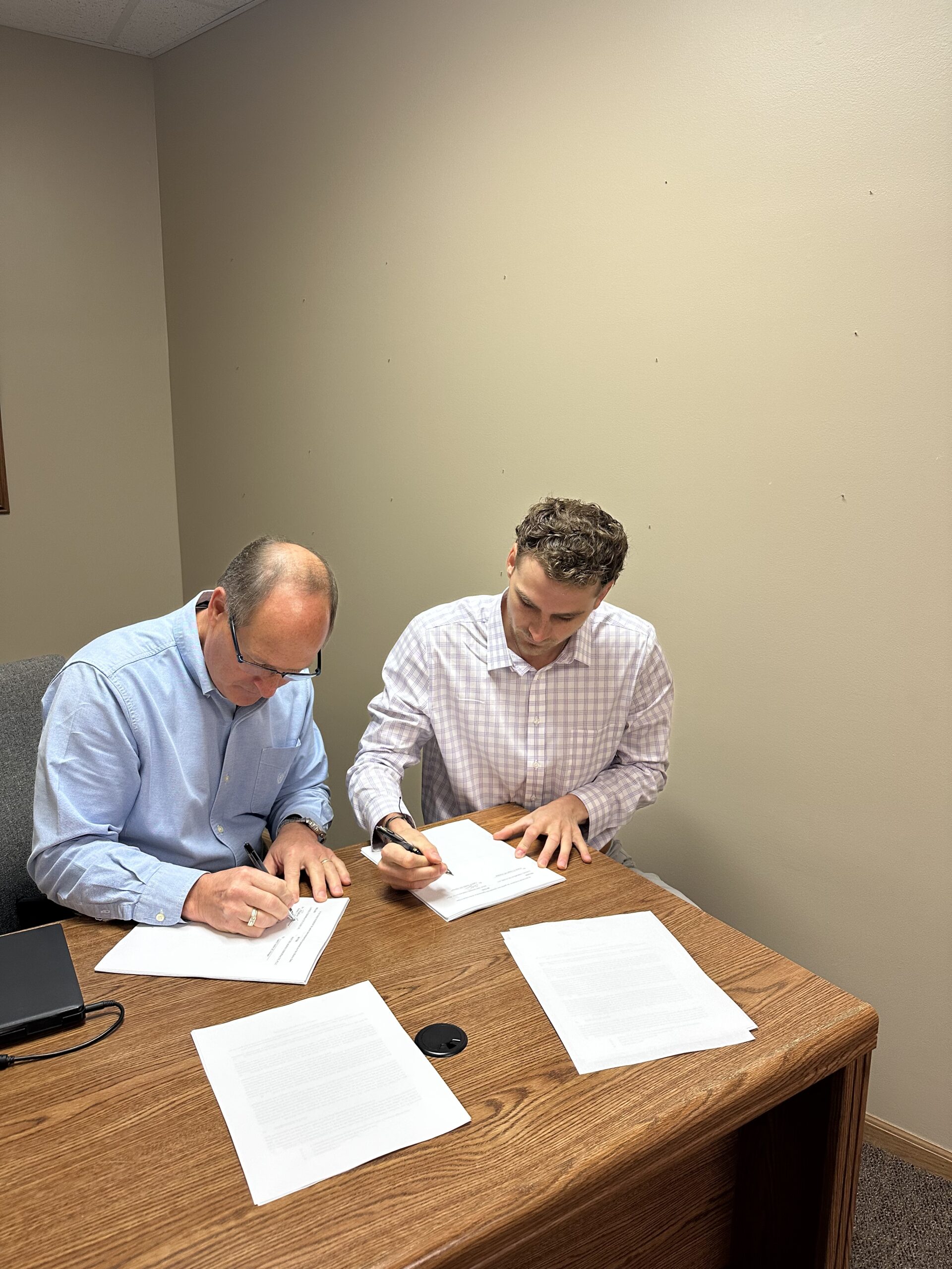 Two men reviewing paperwork together at a table